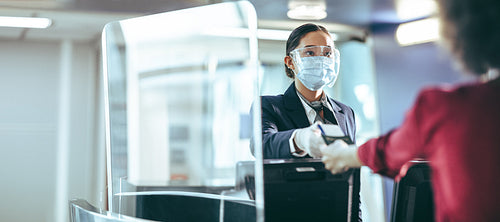 Ground attendant at check in counter assisting passenger