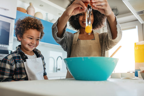 Mother and child in kitchen cooking food together
