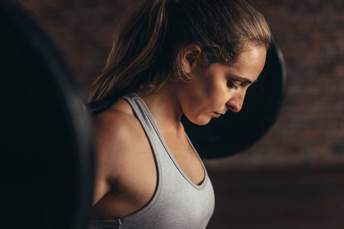 Woman working out at gym with heavy weights