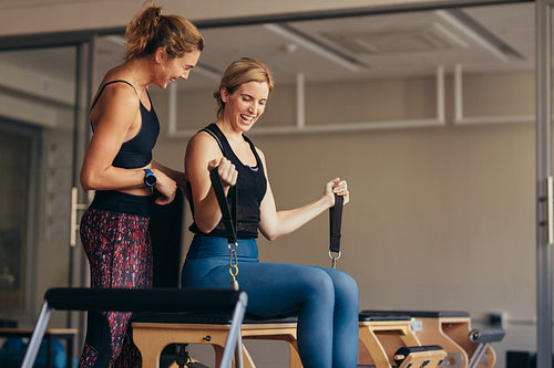 Smiling women doing pilates workout at the gym