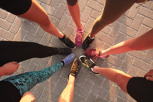 Legs of athletes wearing sport shoes in a circle