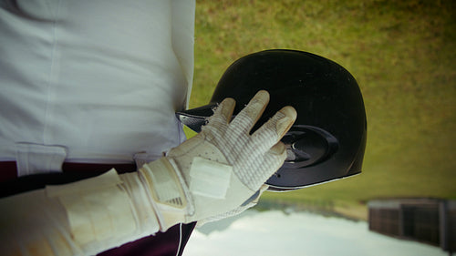 Baseball player dons helmet, ready for the game