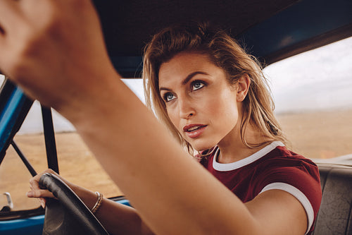 Woman driving car and setting rear view mirror