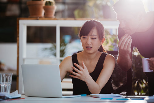 Businesspeople working together on laptop in office