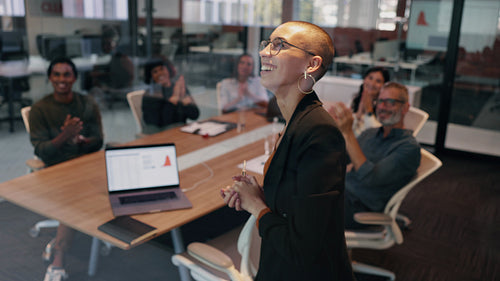 Successful business woman getting applauded by her team as she gives a presentation of her work