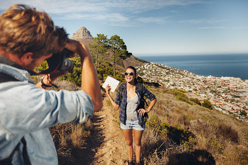 Young couple taking a photo while hiking in the mountains