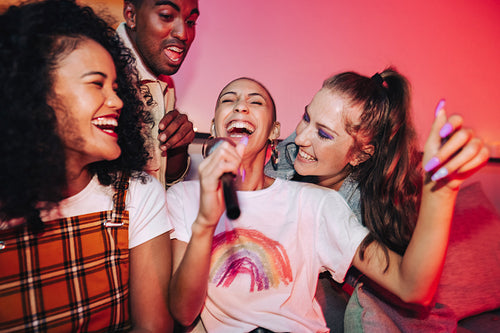 Joyful friends singing during karaoke night