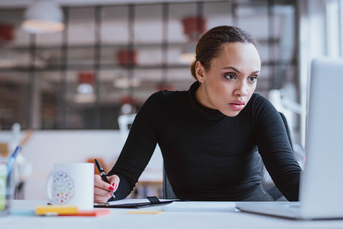 Busy young woman working at her desk