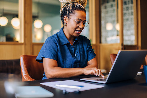 Young black woman working on her laptop in an office setting
