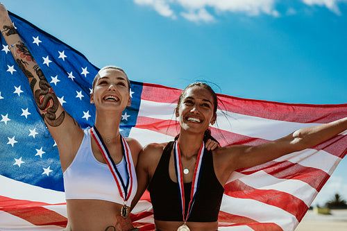 Woman athletes holding up american flag after victory