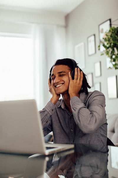 Carefree young man listening to music at home
