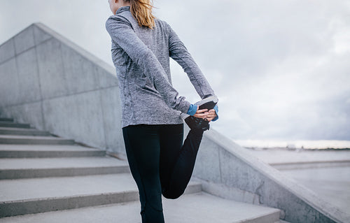 Young fitness woman stretching her leg
