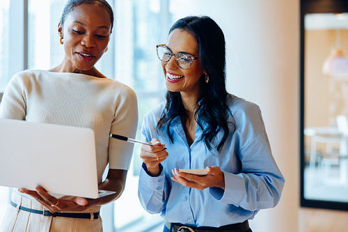 Two women sharing ideas and discussing a project on a laptop