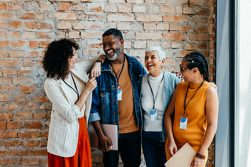 Coworkers laughing and sharing joyful moments in a modern office setting during a casual break