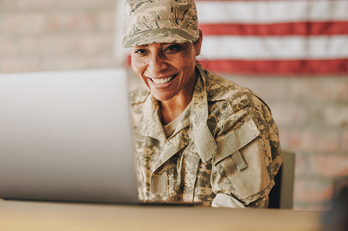 Patriotic female soldier video chatting with her family on a laptop