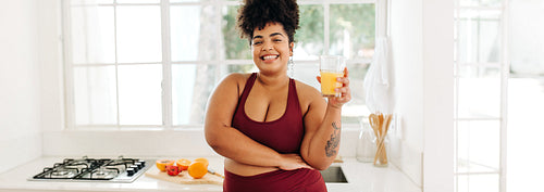 Body positive female with glass of fresh juice