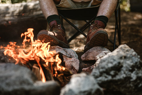 senior man sitting by the campfire
