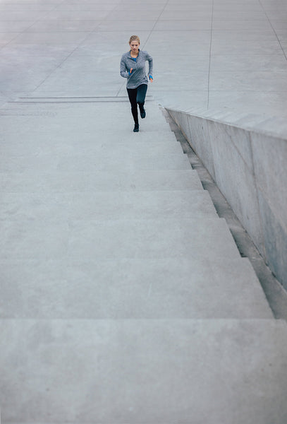 Fitness female running up the steps