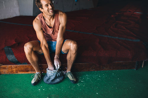 Man wall climber coating hands with gripping powder
