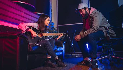 Man and woman composing a song on the guitar
