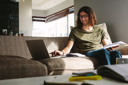 Smiling student using laptop while studying