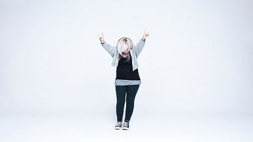 Fashionable woman standing with her hands raised