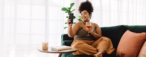 Woman having virtual happy hour with frineds using mobile phone