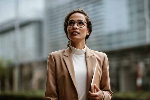Businesswoman holding a digital tablet walking outdoors