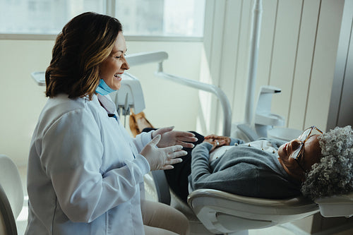 Senior patient converses with dentist during dental clinic visit
