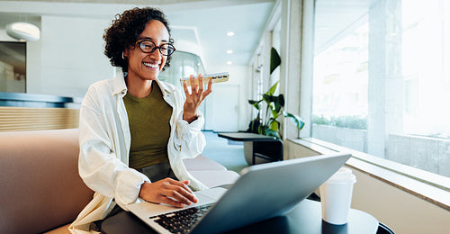 Working woman uses laptop and phone in coworking space