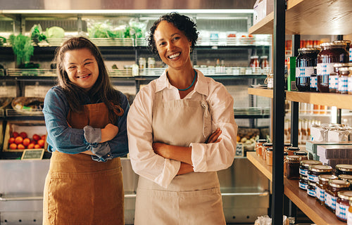 Successful grocery workers smiling at the camera in their shop
