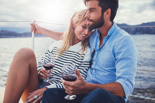 Young couple in love on sail boat with wine
