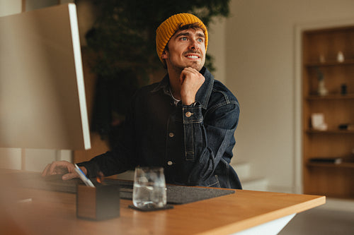 Pensive creative professional sitting at his work desk