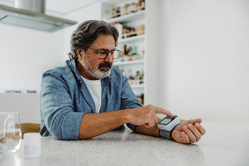 Blood pressure monitor guides senior man at home