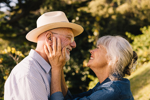 Cheerful senior couple smiling at each other and expressing their affection