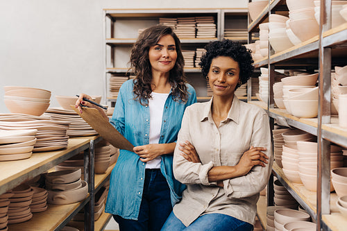 Two female ceramists working together in their shop