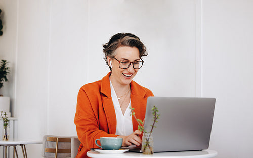 Happy mature businesswoman having a virtual meeting with a client in a cafe