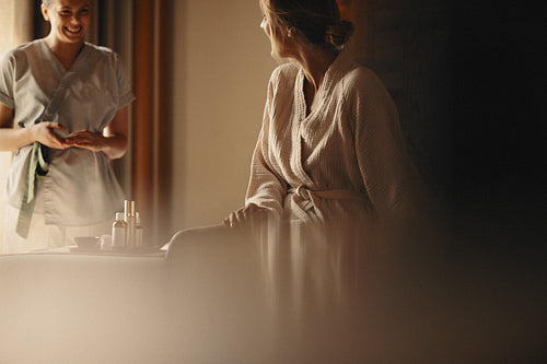 Relaxing spa treatment with professional facialist providing skincare services