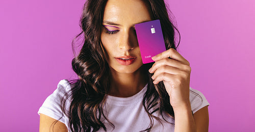 Woman in her 20s holding an exclusive purple credit card in her hand