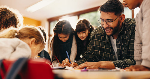 Elementary school educator teaches art to a group of children in a classroom