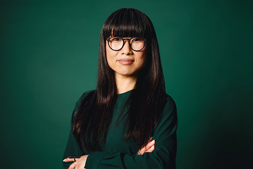 Professional woman standing with glasses in a corporate studio portrait