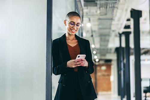 Cheerful businesswoman communicating with her partners using a smartphone