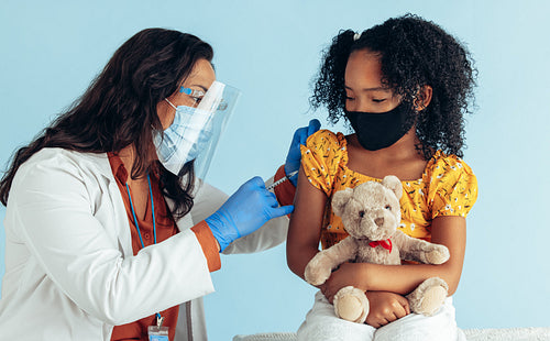 Doctor giving covid-19 vaccine to a girl