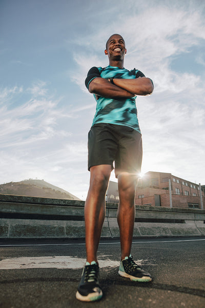 Smiling runner standing on the street in morning