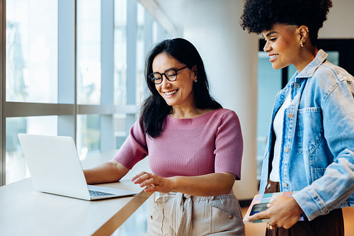 Collaboration between colleagues at laptop in office