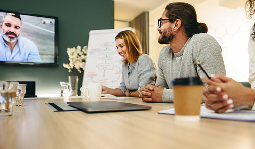Happy businesspeople having a video conference in a boardroom