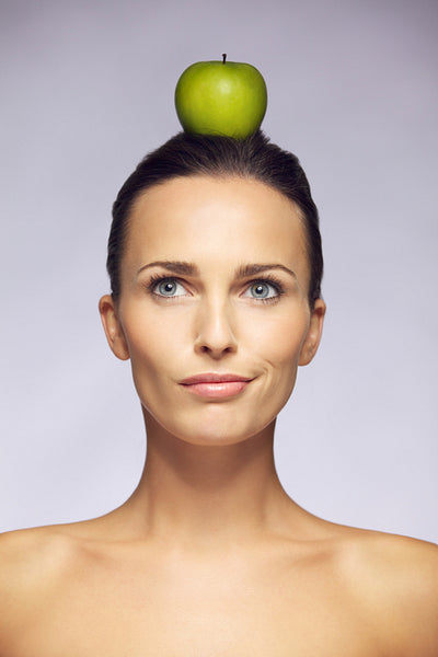 Confused woman with apple on her head