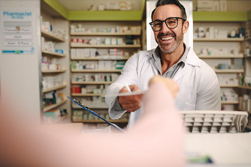 Apothecary taking prescription from customer