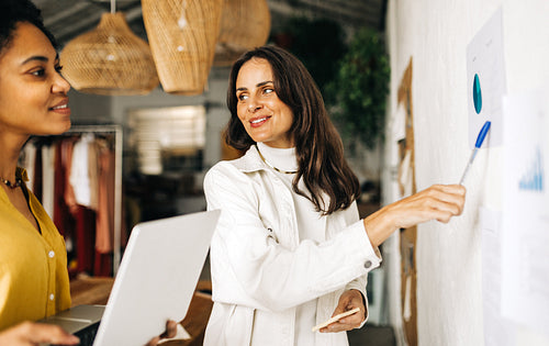 Two business women having a discussion as they collaborate and brainstorm in an office