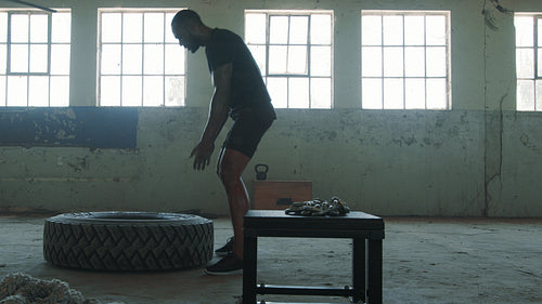Sportsman doing a tire flip exercise at cross training gym